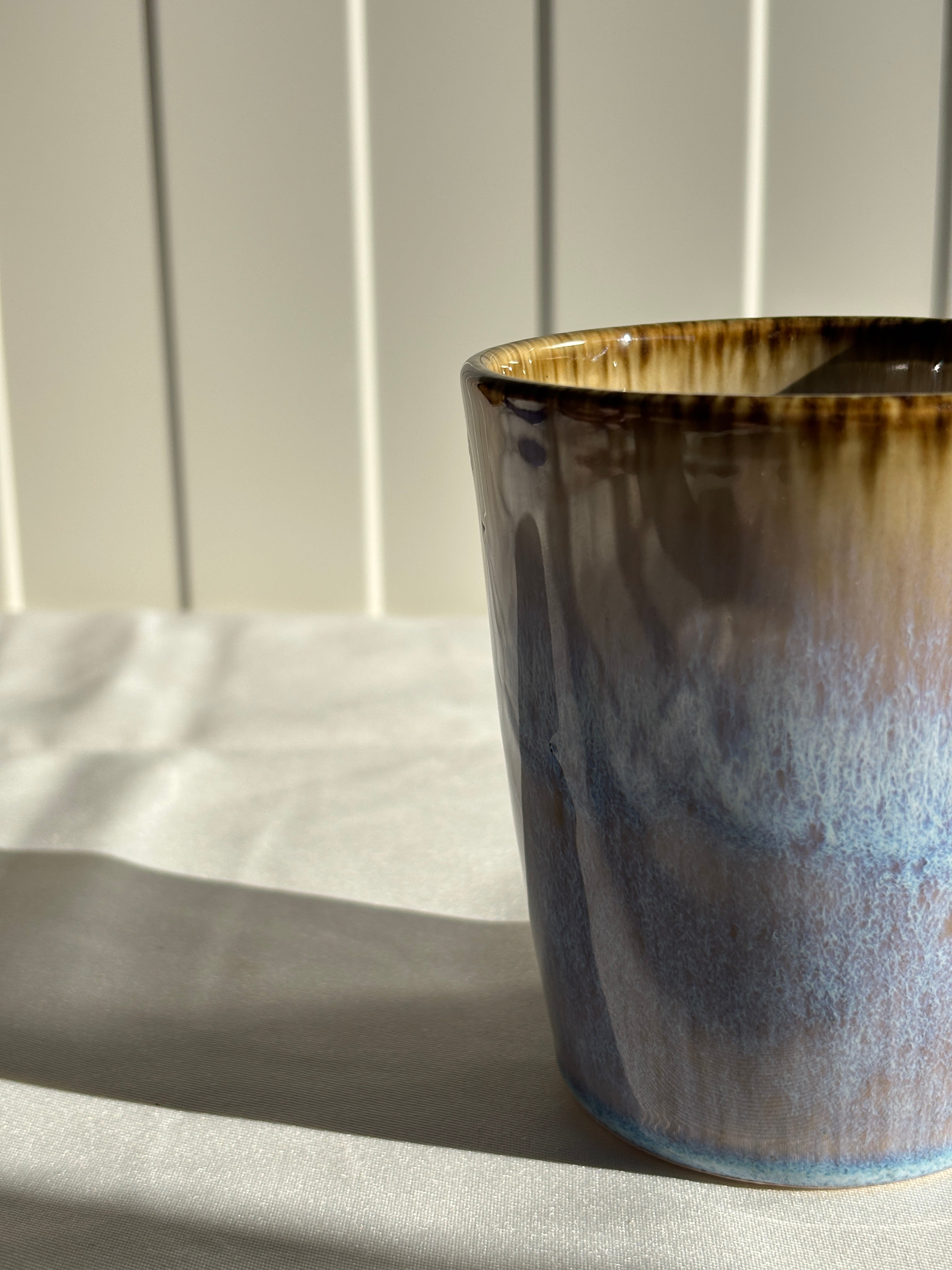 Taza de cerámica hecha a mano con esmalte reactivo azul y marrón