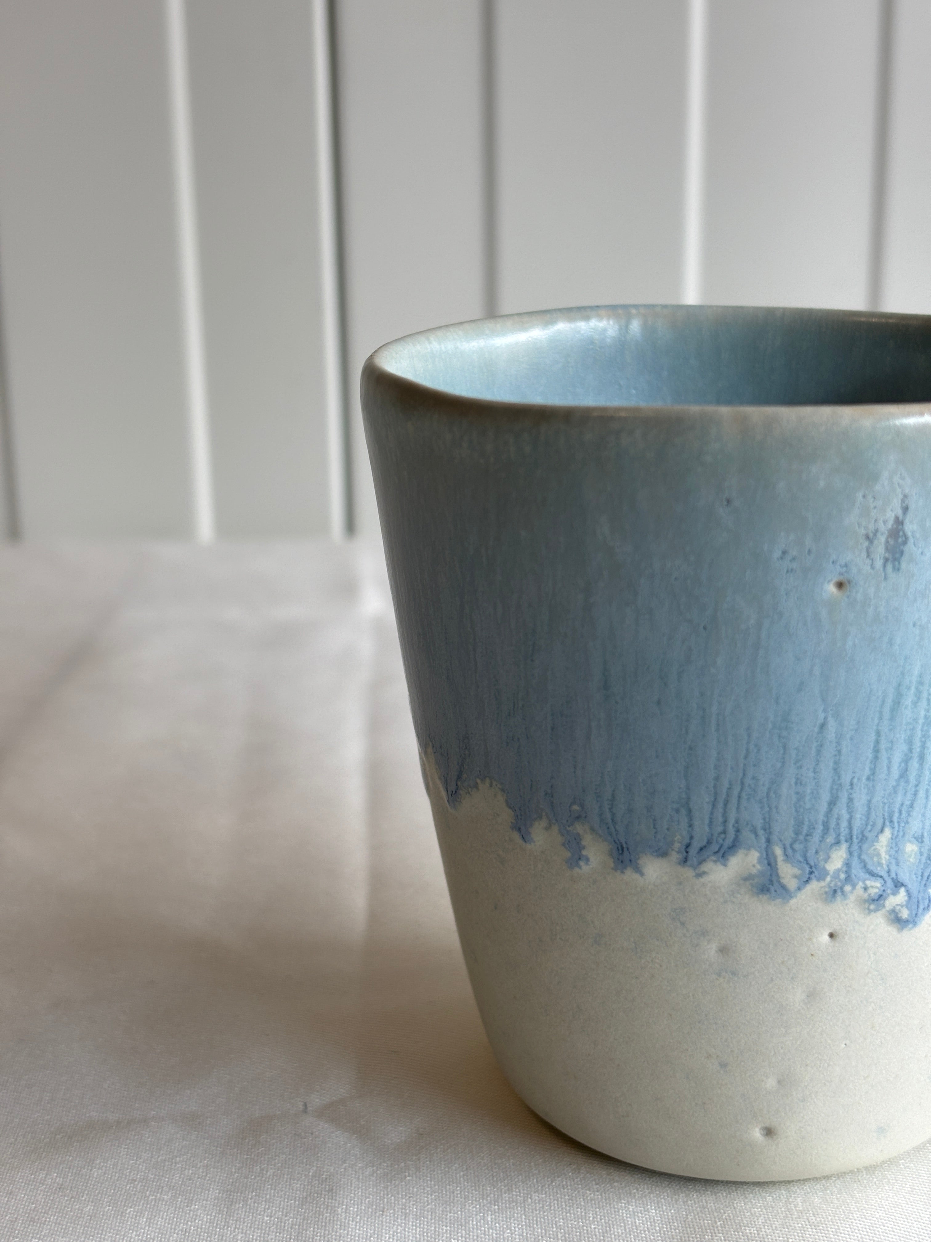 Taza de cerámica bicolor azul y blanca con forma de lágrima, hecha a mano