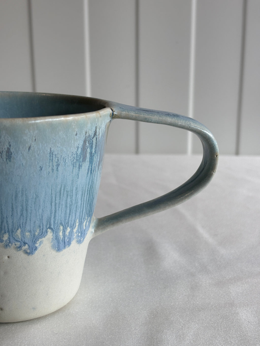 Taza de cerámica bicolor azul y blanca con forma de lágrima, hecha a mano