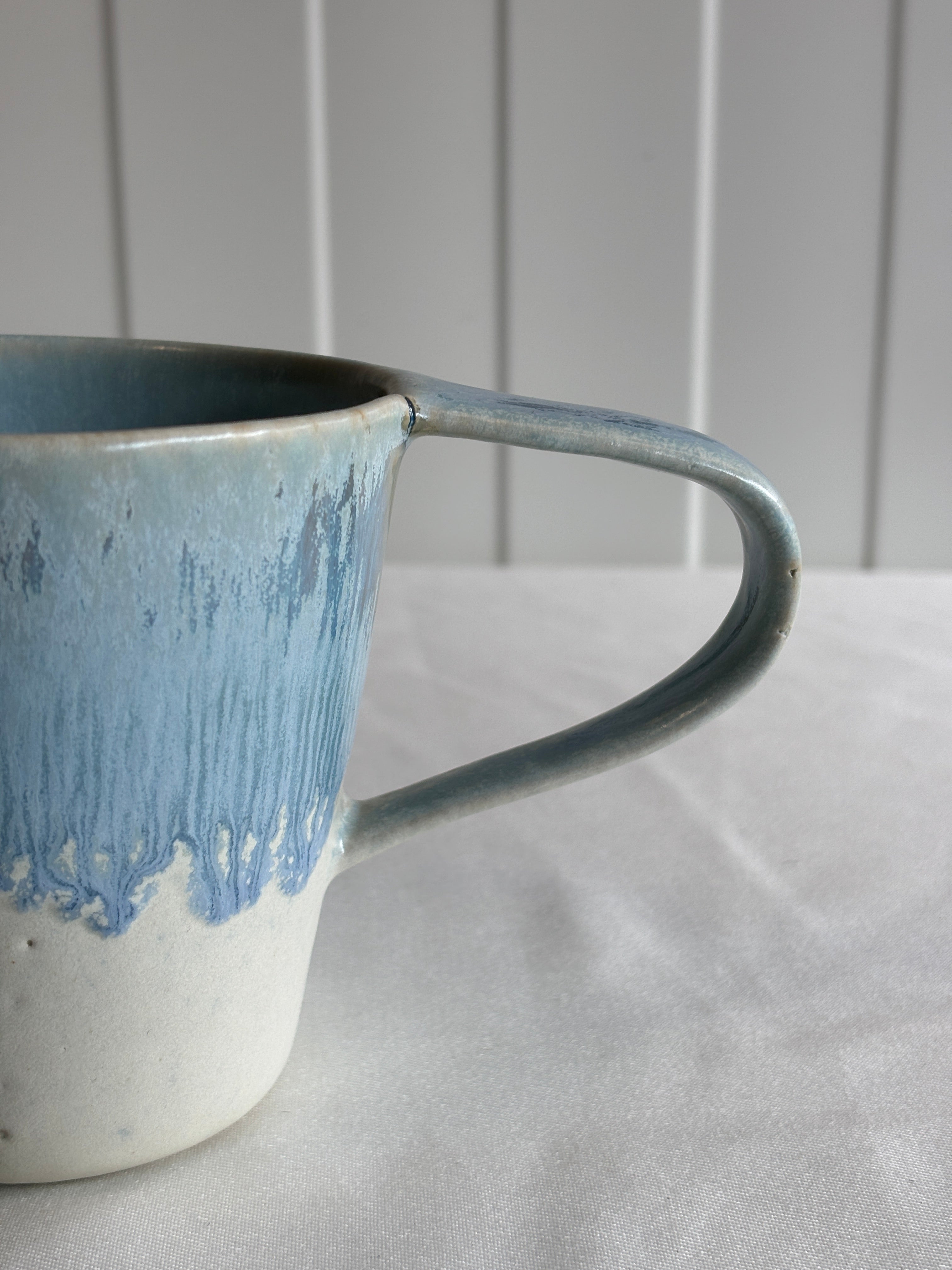 Taza de cerámica bicolor azul y blanca con forma de lágrima, hecha a mano