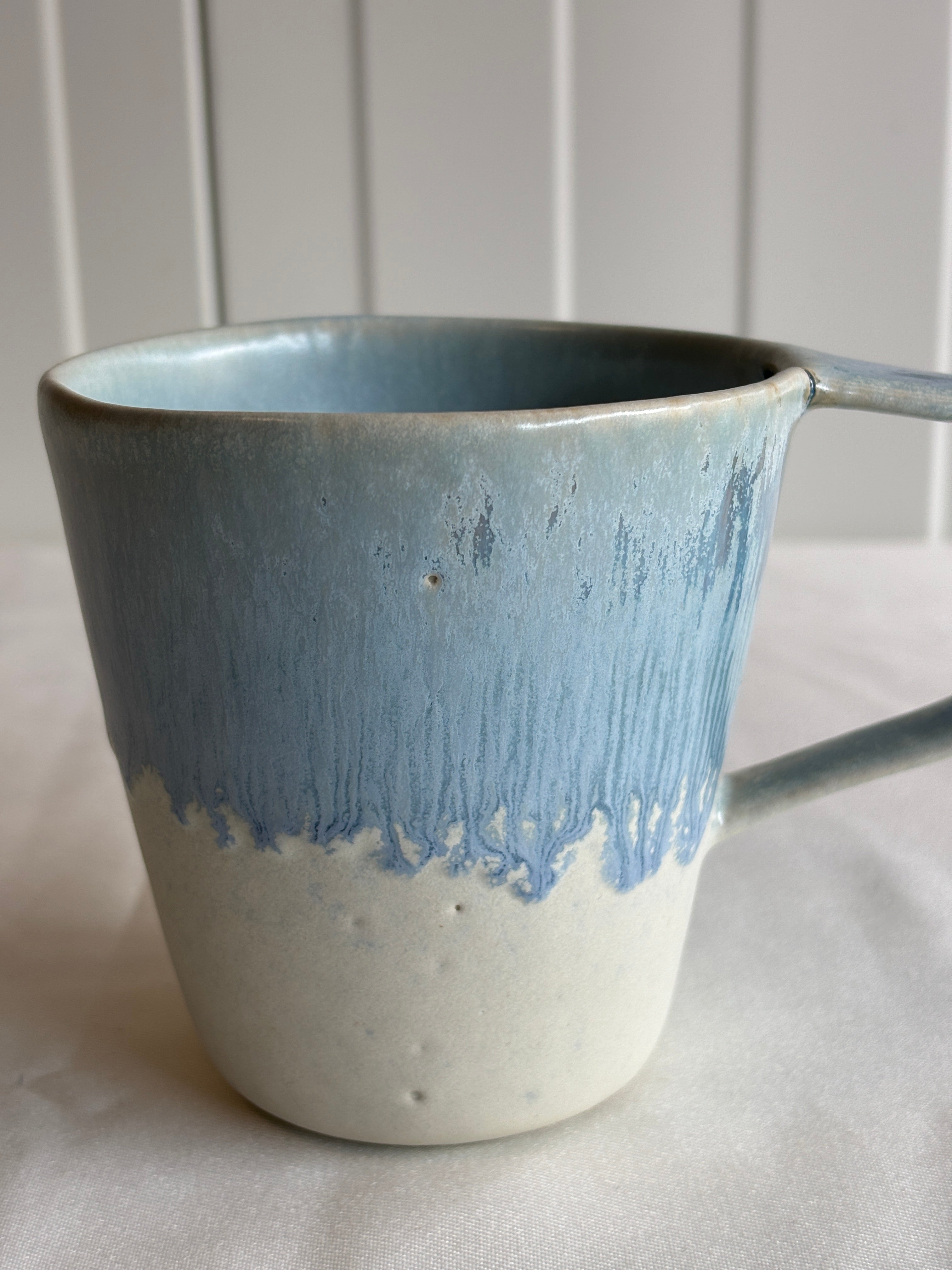Taza de cerámica bicolor azul y blanca con forma de lágrima, hecha a mano