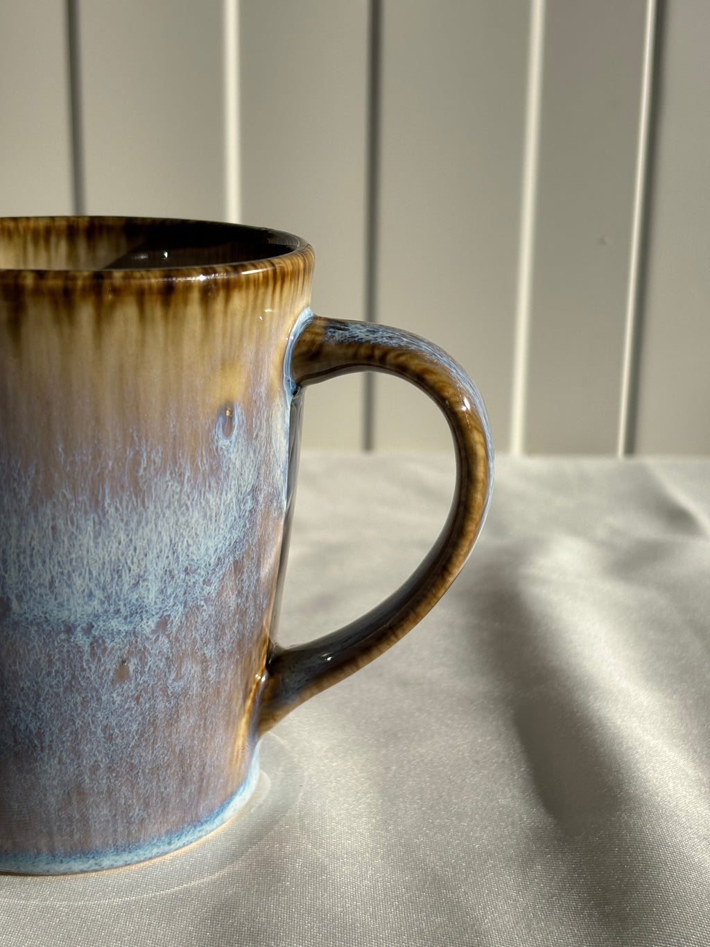 Taza de cerámica hecha a mano con esmalte reactivo azul y marrón